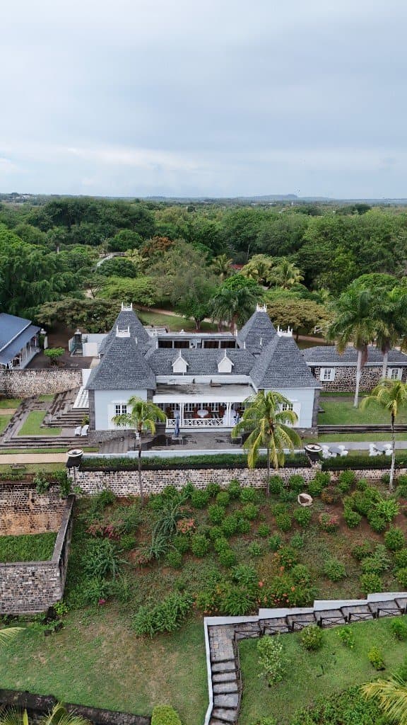 Maison bleue coloniale et jardin vus du drone