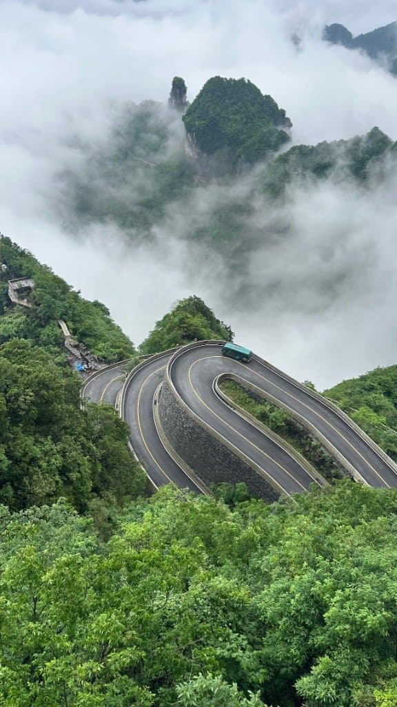 Lacets de montagne, véhicule et brume, photographie aérienne