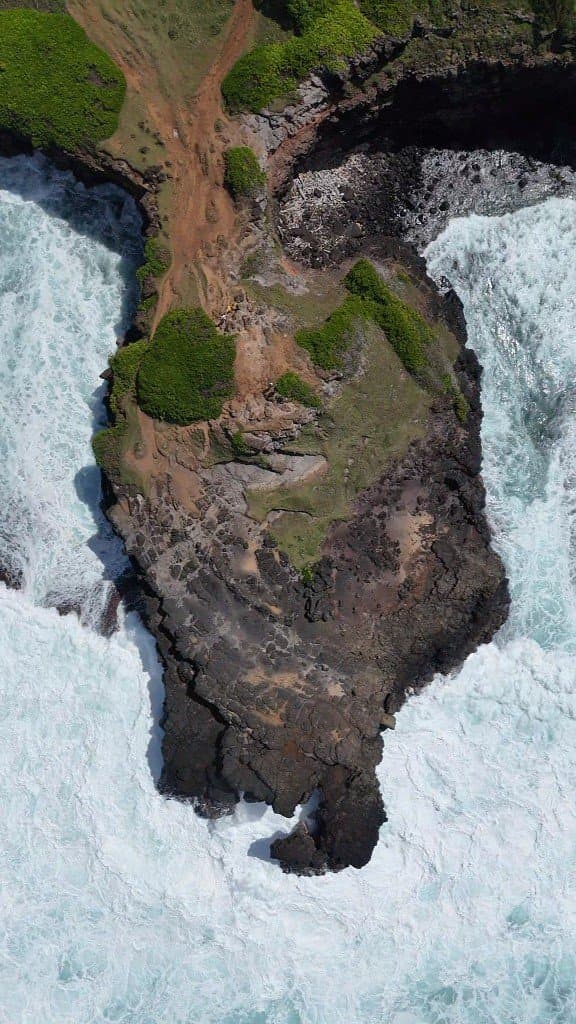 Pointe rocheuse vue du ciel, mer turquoise et écume