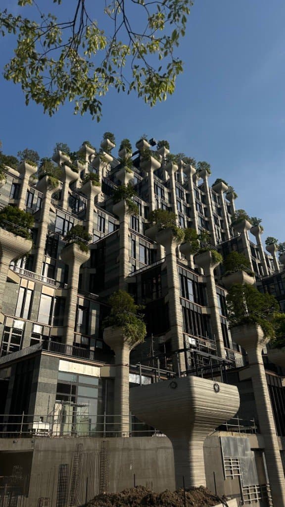 Bâtiment aux piliers végétalisés vu en contre-plongée