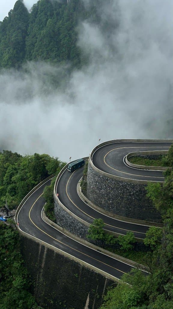 Route de montagne en lacets dans la brume, vue drone